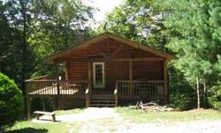 Log home with wrap deck with mature pretty trees in background. It is in the East Port Marina Program. Could be permanent home or a vacation place for all the family to go and relax. There is a seasonal view of Dale Hollow Lake off the back deck. The