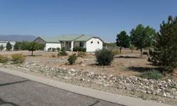 Nice 3/2 stucco home with 10' ceilings, 2 car garage, new covered patio and dog run, metal roof, gas pack, central air and evap cooling. All stainless appliances in kitchen are included as well as all the window coverings. There is tile flooring thru-out