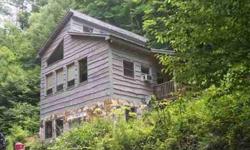 Rough hemlock siding cabin is situated on 10 wooded acres-property is behind house and goes up road to take in 10 acres. Branch is boundary along one side. Cabin is open great room w/bath and double spiral staircase leading to sleeping loft & down to full