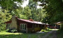 Gorgeous private setting among HUGE oak trees with darling mid-century Frank Lloyd Wright style compact Ranch home filled with windows, natural light, hardwood floors and decks for enjoying your wooded paradise. Newer pole building plus horse barn and