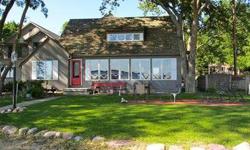 Wonderful sandy beach and a view down the whole lake from this charming lake cottage/home on Haywards Bay on West Lake Okoboji. No steps! Facing south enjoy lake views from a lakeside patio or large family room. Even the den/office has a great lake view.