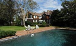 This charming traditional home is located in the estate section of Quogue Village and offers a stunning living room with a unique river stone fireplace and vaulted ceiling. There is a formal dining room, butler's pantry, eatinkitchen, den with French