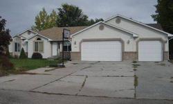 3-car garage is a great bonus for extra storage. This home has a large yard, formal sitting room, family room with a stone fireplaces on each level, vaulted ceilings, hardwood flooring in the kitchen, dining area, and entry, and a spacious kitchen with a