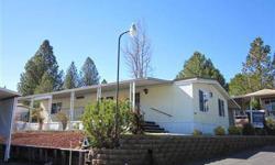 Oakhurst Mobile Home Park invites you to come see this one! Ideally located with High Sierra Views. Enjoy this 2 bedroom, 2 bath home with a propane log stove in the living room and separate den area. Large covered patio in the front to enjoy the Sierra