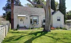 Cute wood-sided 40's cape-cod cottage style house with great curb appeal surrounded by a white picket fence and colorful flower beds. Set back off the street. Open floor plan. Expansive living room with brick fireplace, built-in bookshelves, bay window,