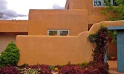 Behind a custom New Mexico gate and tall adobe style wall is a lovely home with many interesting features. It includes a soaring 2 story living room and kiva fireplace. One bedroom is used as a library with ample shelves for your book collection. The