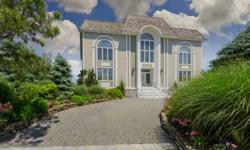 Majestically poised overlooking Moriches Bay, this masterfully designed residence is rich in architectual detail and captures the luminous beauty of the water from every vantage point. The grand, open living spaces are inclusive of a family room with
