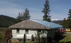 Over forty acres with stunning panoramic views of the mountains from the Green Monarchs to Schweitzer with a chalet perched just above the Pack River Flats. Property is wooded with several benches, a clearing for a small barn/horse set up, rocky