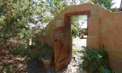 Nestled in a private oasis this adobe home is a one of a kind property. A large clerestory ensures lots of light year round and solar gain in the winter. An open floorplan welcomes you inside and there is a nicely sculpted kiva fireplace in the living