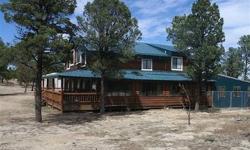 Here's your log home in the mountains. Very secluded feeling on this fully fenced 6 acres. There is a large shop 40 x 60 and another barn 30x30. Beautiful wood throughout the home with soaring ceilings, sun room, wrap around deck - covered and uncovered -