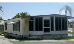 Charming mobile home with a panoramic view is move-in ready! In addition to the 2 bedroom/2 bath open floor plan, outdoor living can be enjoyed year round in the screened enclosure adjacent to the spacious living room. A great space for entertaining