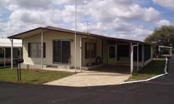 Great location, great price, and great home! What more could you ask for? This beautiful, furnished double-wide mobile home is located on a corner lot in Spanish Trails Village in Zephyrhills, Florida. It is one of the area's most popular mobile home