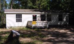 Nice white double wide on slab in a good sized lot; it goes back into the woods, nice setting. Amenities include jacuzzi, nice cabinetry in kitchen, a front porch, and a shed on premises. Call today to learn about our special financing!