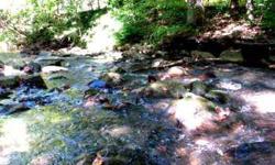 Unrestricted property with over 500 feet of frontage on Junaluska Creek. Level property with large metal storage building. There was once a mobile home here, so there is water, power and septic/sewer hook-up. Believed to be a private well.Listing