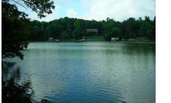 Fantastic waterfront haven, w/ sandy beach, beautiful view, level wooded lot. Well in place, ready for you to build your custom lakehouse. Shoreline stabilized with rip rap. Easy path to lake, come & see! Great location, convenient to restaurants &