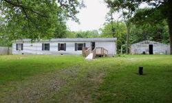 1998 Modest and Clean 3-bedroom mobile home (on a permanent foundation) nestled away on a treed 1+acre lot (not much to mow!) Features wood deck on front with ramp for those with physical challenges, circular drive, large detached garage w/concrete floor,