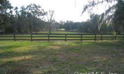 Rolling 81 acres with scattered grand daddy oaks, tree lined driveway, in the nw of horse country, three barn type buildings that have 25+ stalls, round pen, kennel, board fencing surrounding several pastures. Ocala Marion County Association of Realtors
