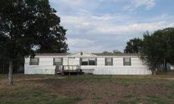 GREAT value for a large manufactured home on a one-half acre lot. Close and convenient to town yet out in the country with a great country feeling. Set on a paved county-maintained road with partial fencing and two storage buildings. Two living areas