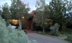 Welcome to this inviting, all Adobe home. It is fronted by beautiful Aspens and Maples, with an East/West siting at the end of a private, paved road. Enjoy 360 views and New Mexico blue skies from this warm and appealing single level retreat. Features