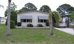 Two bedroom, two bath double-wide mobile home, located in non-pet section of Spanish Lakes Country Club Village. The home has a large raised Florida room, carport, and large patio across rear of the home. Nice area for picnics, etc., with the lake view