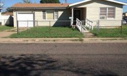 This could be a doll house with some TLC. Features include 2 bedrooms, 1 bath, 1 living area, wall furnace heating and window air conditioning units, carpeting, vinyl, and hardwood floors, and metal and wood fencing. It sits on a corner lot right across