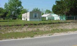 Low price, paved road, and concrete block shop. Great location on CR102 just west of Williston. Partially fenced and cleared 6 acres with well maintained 2 bedroom, 2 bath mobile home. 20' x 50' concrete block shop with electric and water. For more
