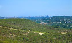 Private, hilltop 1.8 acres of heavily treed land with views of downtown Austin, the Emma Long Preserve, the sunrise and the sunset. Design your dream home atop City Park and in an ideal centralized location and close proximity to Lake Austin, Lake Travis,