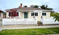 A white picket fence and arbor frame this charming beach house located in the Seabright area. Upgrades include