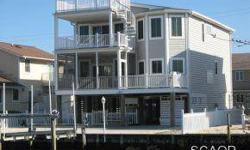 Relax and unwind in this impeccable canal front home with hardwood floors throughout, multiple porches, boat lift and only a short walk to the beach. A beautiful home on the water to enjoy during the summer or all year round. Listing agent and office