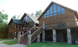 Lake front property for sale in upstate NY on Upper Chateaugay Lake. 2 separate houses connected by a common deck, 100' of sandy beach with docks, stone walkways, patio and firepit. Main house has an open suite downstairs with fireplace, full bath,
