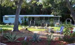 This 2 bedroom/2 bath home on over 1.5 acres is beautifully landscaped with gardens that the owners have worked masterfully on. The mature oak and palm trees that are along the back of the property gives it the "old Florida" look. There is also a full