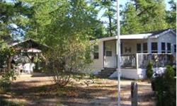 GREAT PARK MODEL WITH BEAUTIFUL PINE ADD-A-ROOM. This unit has a desirable end kitchen, large bath, built-ins and a large deck. There is a lot of storage in this unit. Huge lot, canopy, wood shed, outbuilding, lots of privacy and some nice landscaping.