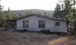 Want some privacy??? How about 20 acres in the tall pines w/3 bedroom, 2 3/4 bath doublewide with covered decks. Has its own well, horse corrals, workshop, separate garage and storage. Borders National Forest on 2 sides. Abundant wildlife. Bring horses or